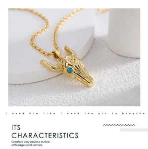 Detail of bull skull pendant in gold finish with turquoise stone and poetic quote