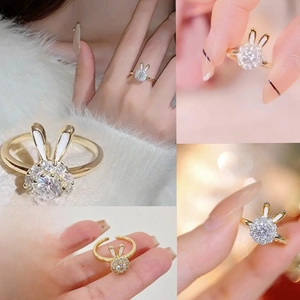 Close-up of a gold spinning rabbit ring with white zircons and adjustable open band