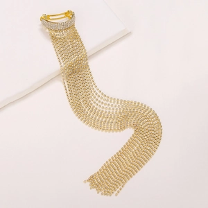 Elegant gold ponytail clip with long rhinestone tassels on white geometric prop