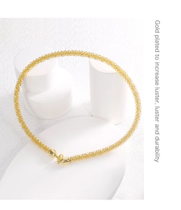 Close-up of gold plated necklace with fine texture detail and English descriptive text