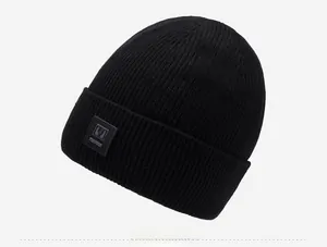 Detail of black winter beanie with ribbed knit texture and side logo patch for men