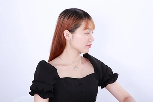 Model wearing silver geometric necklace and earring set with shimmering cubic zirconia