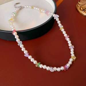 Detail of minimalist pearl necklace with colorful碎石 gemstones and metal clasp closure