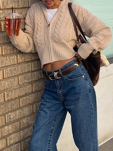 Dettaglio di un cardigan in maglia beige a trecce con jeans a vita alta e borsa