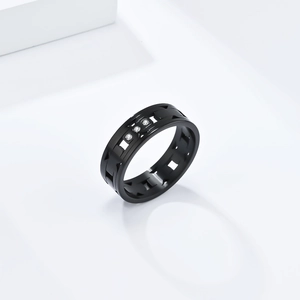 Titanium steel ring with laser-cut hollow design and three inset diamonds on white background