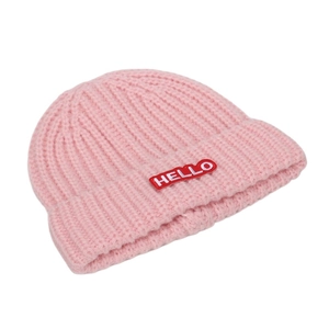 Vue détaillée du bonnet en maille rose avec écusson HELLO cousu sur fond blanc pur