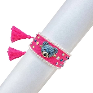 Exquisite hand-woven pink friendship bracelet featuring a sparkly rhinestone bear and tassels
