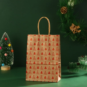 Detail of kraft paper Christmas gift bag with red tree prints on dark green background