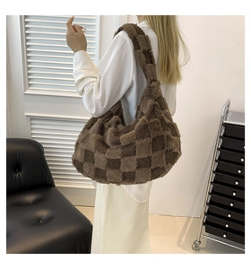 Brown plush checkerboard tote bag shown on shoulder of a model in white casual outfit