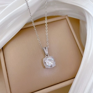 Close-up of silver titanium steel necklace with square halo pendant on white silk