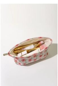 Internal view of floral makeup bag showing capacity for brushes and cosmetics