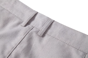Detailed macro view of the waistline and belt loops on light grey cotton linen trousers