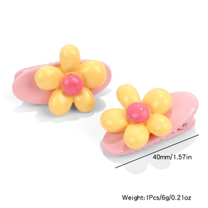 Detail of yellow flower hair clips showing 40mm length and 6g weight measurement