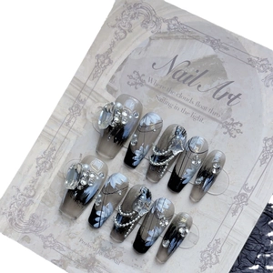 Black gradient press-on nails with floral art, large rhinestones and pearls
