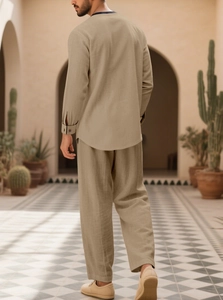 Rear view of casual beige linen shirt and trousers set in a Mediterranean style courtyard
