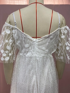 Close-up of white wedding dress back with embroidered lace, sequins, and puff sleeves