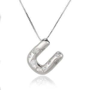 Detailed macro shot of silver horseshoe pendant necklace with inlaid clear cubic zirconia