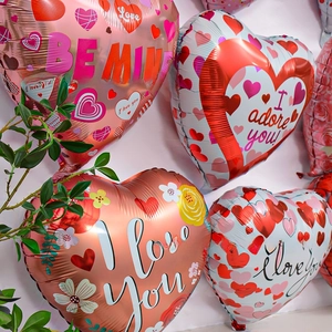 Macro shot of heart-shaped foil balloons with I Love You and Be Mine romantic prints