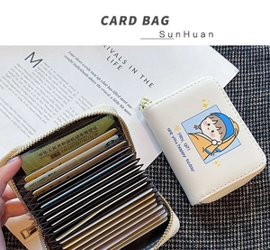 Detail of white leather card holder with cute art print and multi-slot accordion interior