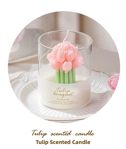 Detail of pink tulip flower scented candle in clear glass cup on a porcelain plate