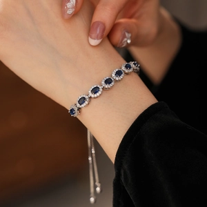 Détail d'un bracelet ajustable en argent avec pierres bleues ovales sur le poignet