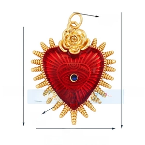 Detailed view of red heart pendant with gold rose and blue gemstone eye detail