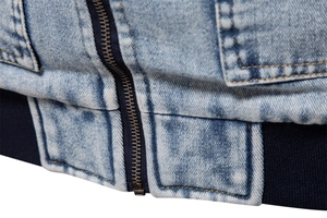 Close-up of light blue washed denim jacket with zipper closure and ribbed hem detail