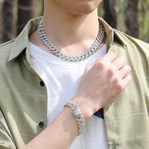 Gros plan d'un ensemble de collier et bracelet cubain argenté pour homme avec strass brillants
