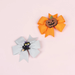 Detail of Halloween bow clips featuring ribbed ribbon with pumpkin and black cat motifs