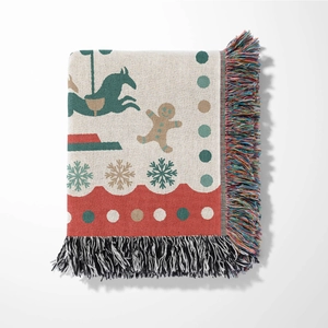 Detail of a festive Christmas woven throw blanket with colorful tassels and holiday patterns