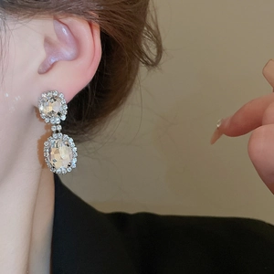 Close-up of double-layer teardrop crystal earrings on model with silver-tone setting