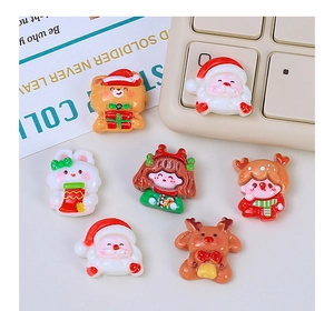 Flat lay of colorful Christmas resin charms including Santa, bear, and reindeer motifs