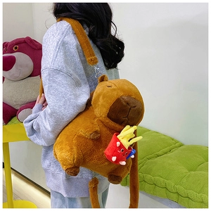 Detailed view of Capybara plush backpack with red french fries accessory on model back