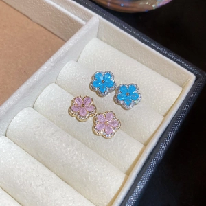 Detailed view of silver flower earrings with blue and pink cubic zirconia crystals