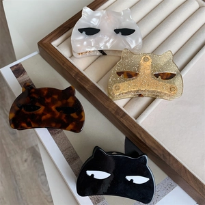 Detail of cat-shaped acetate hair claws in marble, glitter, tortoiseshell, and black