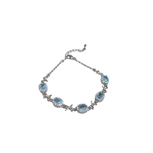 Silver bracelet with oval blue zircons and bow accents, elegant light luxury design
