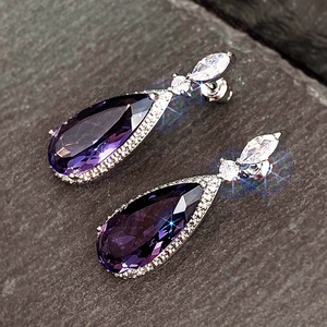 Macro d'une boucle d'oreille goutte en zircon violet avec pavé de micro-diamants