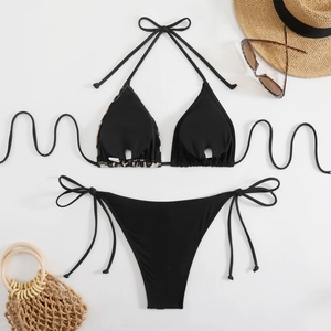Macro detail of black halter bikini with leopard trim and beach vacation accessories