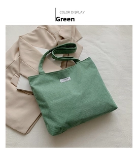 Detail of green corduroy tote bag with Fashion patch on a beige blazer background