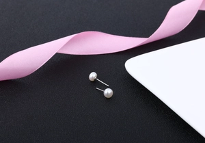 Detailed macro view of S925 silver stud earrings with natural white freshwater pearls