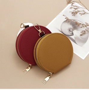Macro shot of red and tan lychee grain leather mini coin purses with gold zippers