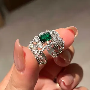Macro shot of vintage silver ring featuring an emerald green zircon with hollow floral band