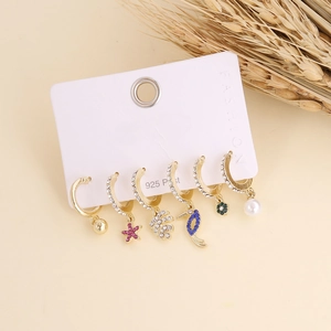 Detail of bohemian gold earring set with rhinestones and pearls on a display card