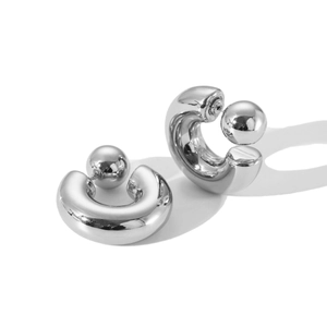Macro shot of polished silver stainless steel C-shape hoop earrings with ball backing