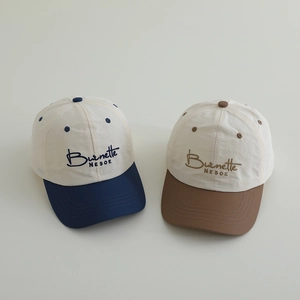 Detail of color-blocked kids baseball caps with embroidered lettering in navy and brown