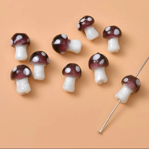 Macro shot of purple glass mushroom beads with white spots for DIY jewelry making