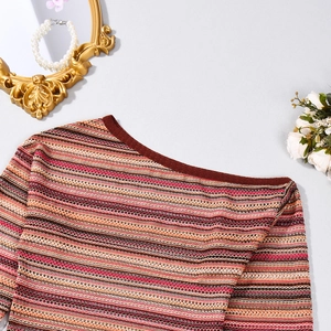 Close-up of colorful striped knit fabric with delicate openwork and ribbed red neckline