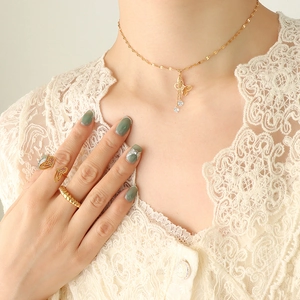 Elegant gold butterfly necklace and ring set with zircons on a model in lace attire