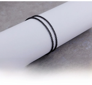 Detail of a black stainless steel rolo chain necklace with modern polished finish