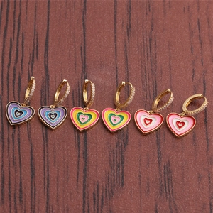 Close-up of six pairs of gold heart earrings with colorful enamel and crystal accents